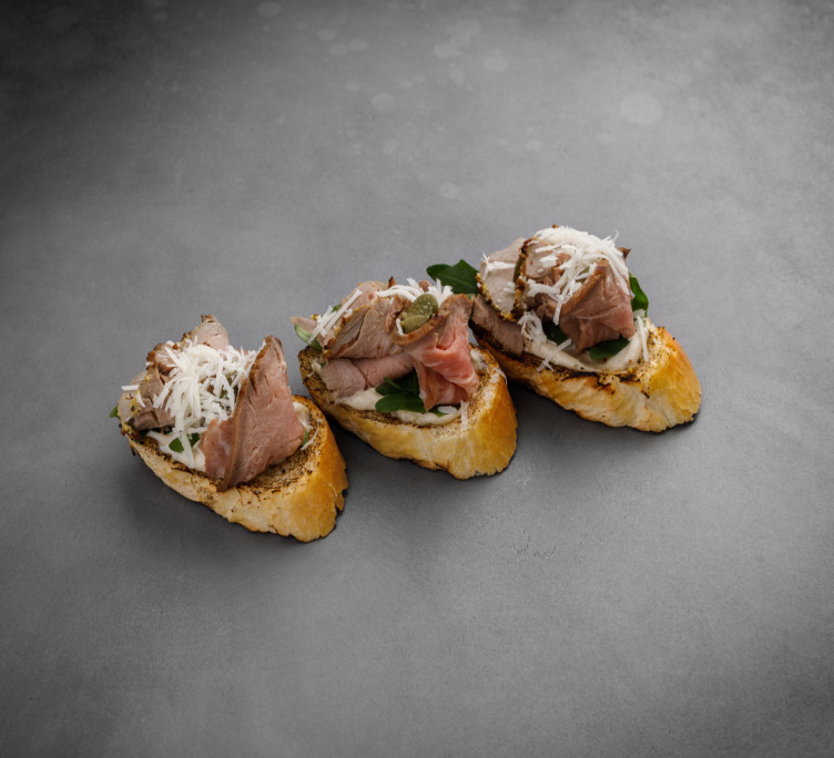 Брускетта с сочным ростбифом, рукколой и королевским каперсом 